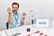 Middle age man with beard sitting by ballot holding i vote badge doing italian gesture with hand and fingers confident expression