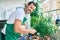 Middle age man with beard smiling happy watering the plants at the terrace