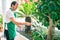 Middle age man with beard smiling happy watering the plants at the terrace