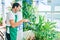 Middle age man with beard smiling happy watering the plants at the terrace