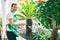 Middle age man with beard smiling happy watering the plants at the terrace