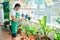 Middle age man with beard smiling happy watering the plants at the terrace