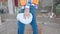 Middle age man builder holding hardhat walking at construction site