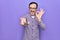 Middle age man changing tv channel using television remote control over purple background doing ok sign with fingers, smiling