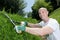 Middle-age man grass cutting in garden