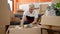 Middle age man with grey hair unpacking cardboard box at new home