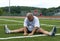 Middle age man stretching on sports field