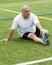 Middle age man stretching on sports field