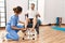 Middle age man and woman having rehab session pedaling sitting on wheelchair at physiotherapy clinic