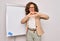 Middle age senior business woman standing on seminar presentation by magnectic blackboard smiling in love doing heart symbol shape