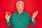 Middle age senior grey-haired man holding romantic red heart object over isolated red background very happy and excited, winner