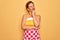 Middle age senior pin up housewife woman wearing 50s style retro dress and apron with hand on chin thinking about question,