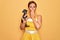 Middle age senior pin up woman wearing 50s style retro dress holding chihuahua dog cover mouth with hand shocked with shame for