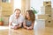 Middle age senior romantic couple lying on the floor, smiling happy for moving to a new house, relaxing and taking a break of