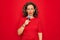 Middle age senior singer woman singing using music microphone over red background with a confident expression on smart face