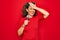 Middle age senior singer woman singing using music microphone over red background stressed with hand on head, shocked with shame