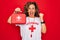 Middle age senior summer lifeguard woman holding first aid kit over red background screaming proud and celebrating victory and