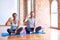 Middle age sporty couple sitting on mat doing stretching yoga exercise at gym smiling and confident gesturing with hand doing