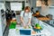 Middle age woman following a cooking tutorial video course on laptop while preparing meal in a kitchen. Woman cooking