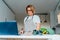 Middle age woman following a cooking tutorial video course on laptop while preparing meal in a kitchen. Woman cooking