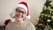 Middle age woman with grey hair smiling by christmas tree at home