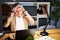 Middle age woman with grey hair working using computer laptop late at night covering ears with fingers with annoyed expression for