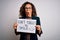 Middle age woman holding banner with dont forget smile message over white background scared in shock with a surprise face, afraid