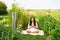 Middle age woman meditating in green garden