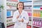 Middle age woman pharmacist smiling confident make mixture at pharmacy