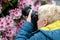 Middle age woman photographing the blooming rhododendrons