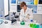 Middle age woman scientist measuring liquid at laboratory