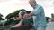 Middle age woman sitting on bench of park with old man hugging her from the back. Couple of retired people relaxing and enjoying