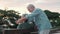 Middle age woman sitting on bench of park with old man hugging her from the back. Couple of retired people relaxing and enjoying