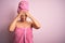 Middle age woman wearing bath towel from beauty body care over pink background suffering from headache desperate and stressed