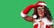 Middle age woman wearing Santa Claus costume very happy and smiling looking far away with hand over head
