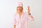 Middle age woman wearing sleep mask and pajama over  white background showing and pointing up with fingers number three