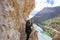 Middle aged and adventurous woman with helmet taking pictures on a cliff