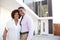 Middle aged African American  couple stand outside admiring their modern home, back view