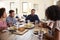 Middle aged African American  man sitting at the table eating dinner with his wife and family, close up