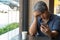 Middle-aged Asian men 40 years old, stressed and tired and using smartphone, are sitting in fast restaurant. On the table there