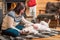 Middle-aged Asian woman strokes Labrador dog lying on blanket in front of a fireplace in a country house