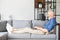 Middle-aged bearded man lying down on the couch with a laptop