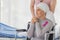 A middle-aged breast cancer woman with clothing around her head effected from chemo therapy sitting on wheel chair and hold hand