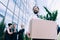 Middle aged businessman holding cardboard box while colleagues standing and talking behind