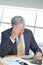 Middle aged Businessman Seated at His Desk