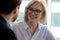 Middle-aged businesswoman talking with partner during meeting in office