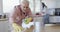 Middle aged caucasian couple cleaning kitchen at home, slow motion