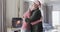 Middle aged caucasian couple in santa hats cuddling at christmas at home, slow motion