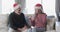 Middle aged caucasian couple in santa hats talking at christmas at home, slow motion