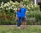 Middle-aged Caucasian man and his Korean wife posing in front of a bed of beautiful flowers in Bar Harbor, Maine.